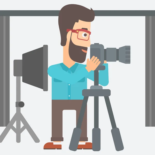 Photographer working with camera on a tripod. — Stockvector