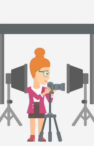 Fotógrafo trabajando con cámara en un trípode . — Vector de stock