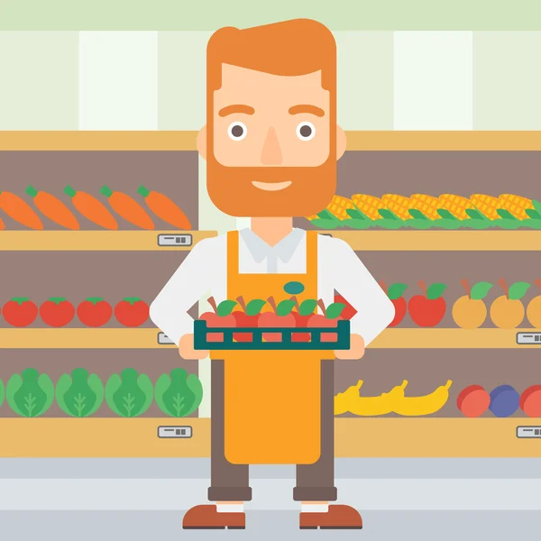 Supermarkt werknemer met een doos vol met appels. — Stockvector