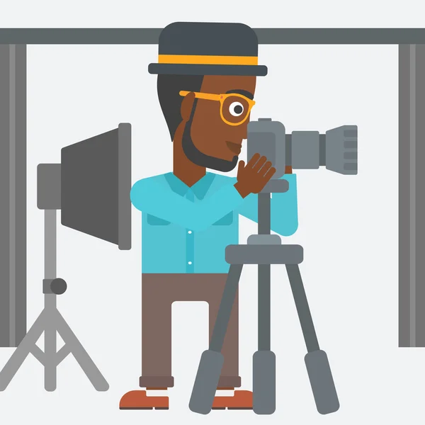 Photographer working with camera on a tripod. — Stock Vector