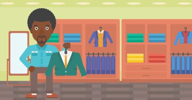 Giyim mağazasında takım elbise ceket tutan adam.