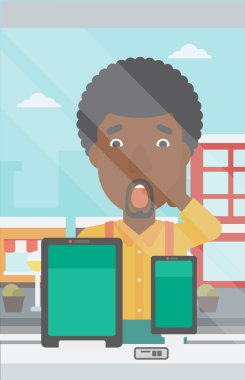 Dijital tablet ve akıllı telefona bakan adam.