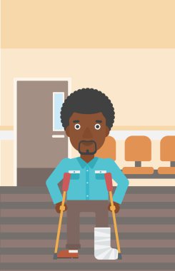 Kırık bacak ve koltuk değneği olan adam.