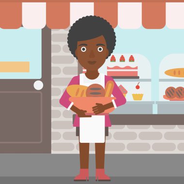 Baker holding sepet ekmek yapım ürünleri ile.