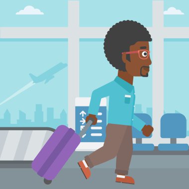 Havaalanında bavul ile yürüyen adam.