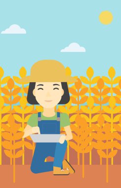 Woman with tablet computer on field.