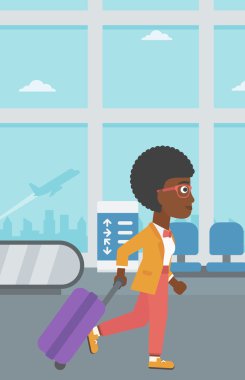 Havaalanında bavul ile yürüyen kadın.