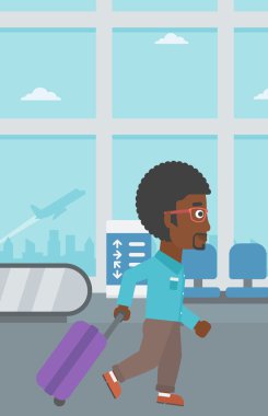 Havaalanında bavul ile yürüyen adam.