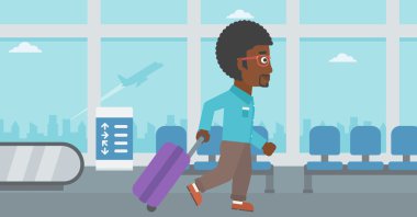 Havaalanında bavul ile yürüyen adam.