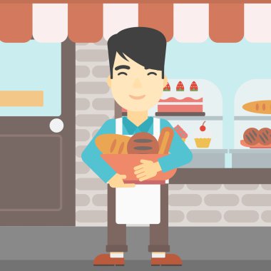 Baker holding sepet ekmek yapım ürünleri ile.