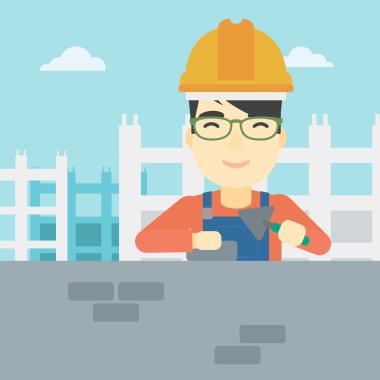 Duvarcı ustası spatula ve tuğla ile.