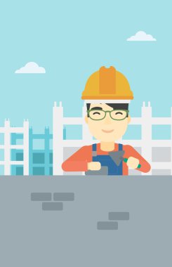 Duvarcı ustası spatula ve tuğla ile.