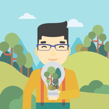 Adam ampul ve ağaçlar içinde.