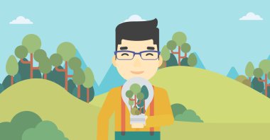 Adam ampul ve ağaçlar içinde.