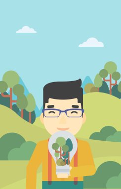 Adam ampul ve ağaçlar içinde.