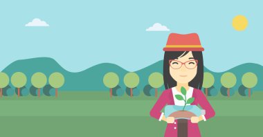 Plastik şişede büyüyen bitki tutan kadın.