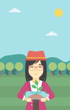 Plastik şişede büyüyen bitki tutan kadın.