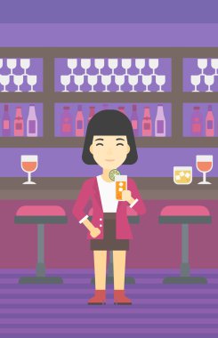 Woman drinking orange cocktail at the bar.