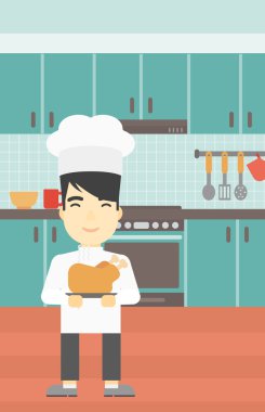 Şef tencere tutarak kavrulmuş tavuk.