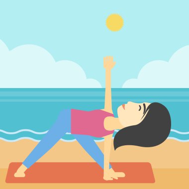 Woman practicing yoga triangle pose on the beach.