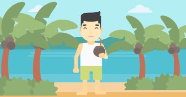 Sahilde hindistan cevizi kokteyli içen adam.