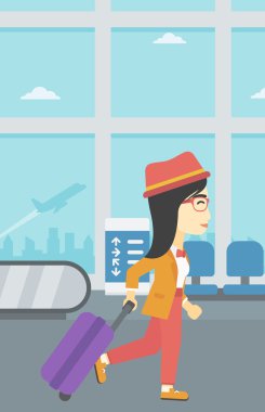 Havaalanında bavul ile yürüyen kadın.