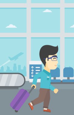 Havaalanında bavul ile yürüyen adam.