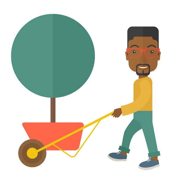 Jovem africano empurrando a carroça com árvore . — Vetor de Stock