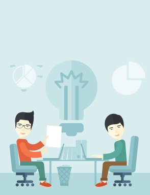 Two japanese businessmen sitting working together.