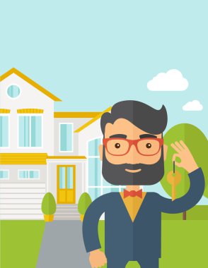 Real estate agent holding a key infront of the house