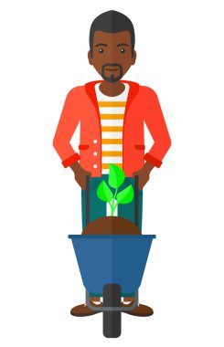 Adam bitki ve el arabası.