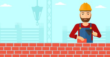 Duvarcı ustası spatula ve tuğla ile.