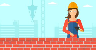 Duvarcı ustası spatula ve tuğla ile.