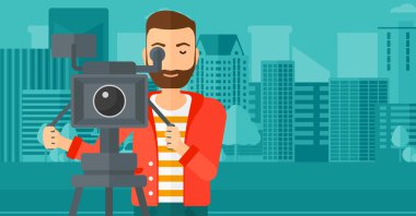 Cameraman with movie camera on a tripod.