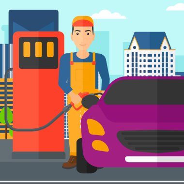 Adam arabasına yakıt dolduruyor.