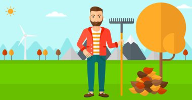 Komisyon duran ağaç ve sonbahar yaprak yığını yakın olan adam.