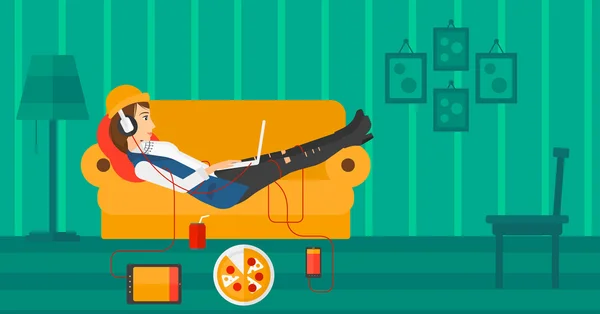 Donna sdraiata sul divano con molti gadget . — Vettoriale Stock