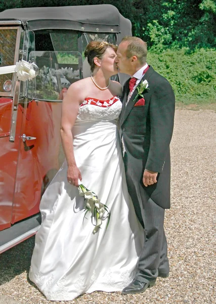 Kissing in front of Wedding Car Royalty Free Stock Photos