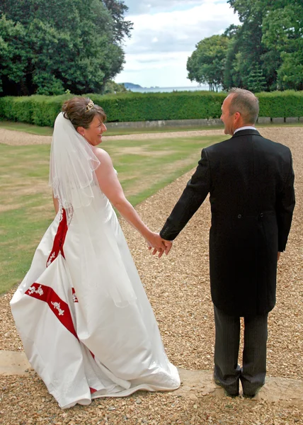 Baksidan av bruden och brudgummen hand i hand — Stockfoto