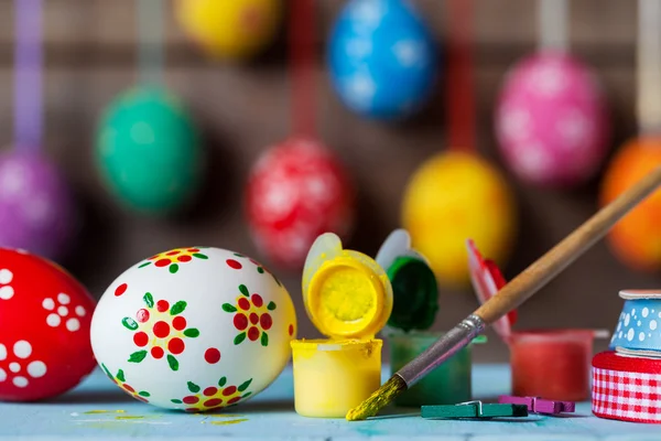 Målade påskägg och hängande färgglada ägg på bakgrund — Stockfoto