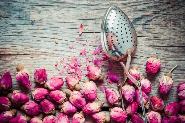 Infusor de té y té de brotes de rosa secos. Vista superior . —  Fotos de Stock