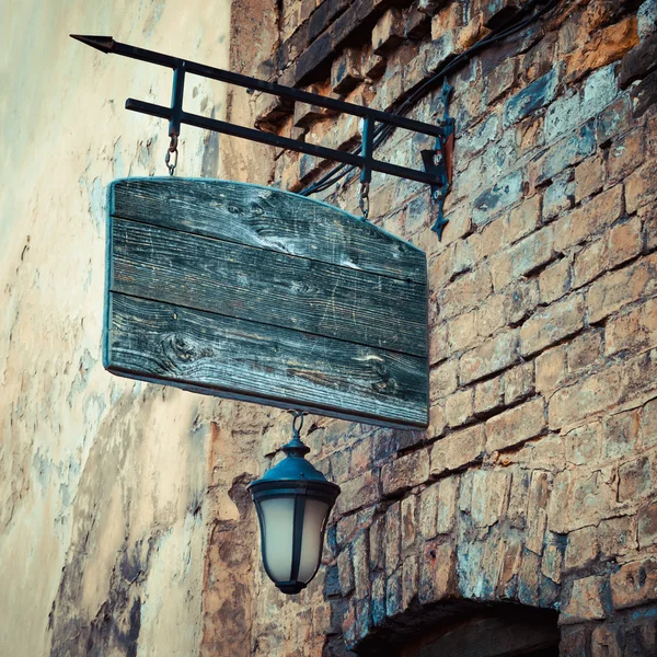 Cartello rustico in legno su muro di mattoni medievali invecchiati — Foto Stock