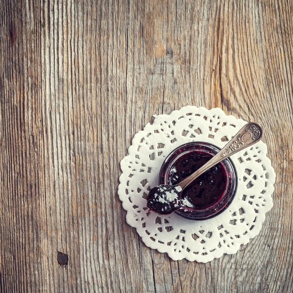 Jar of jam with spoon on old wooden table. Top view. — Stock Photo, Image