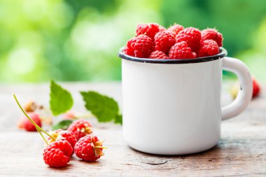Kupa masada açık havada beyaz taze ahududu emaylanmış.