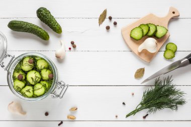 Cucumbers ready for pickling and ingredients on white table. clipart