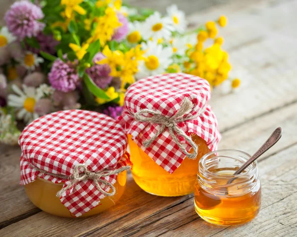 Jars of honey and healing herbs. — Stock Photo, Image