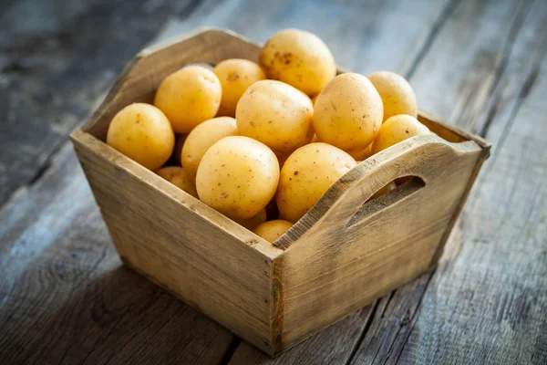 Potatoes in wooden box on table. — Stock Photo, Image