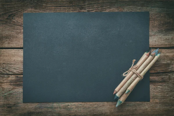 Gray paper sheet and pencils. Top view. — Stock Photo, Image