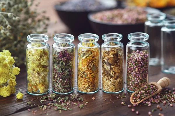 Glasflaschen Mit Heilkräutern Helichrysum Wilder Majoran Ringelblumen Gänseblümchen Heidekraut Trauben — Stockfoto