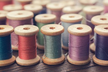 Çok renkli ipliklerin çeşitli eski ahşap makaraları.